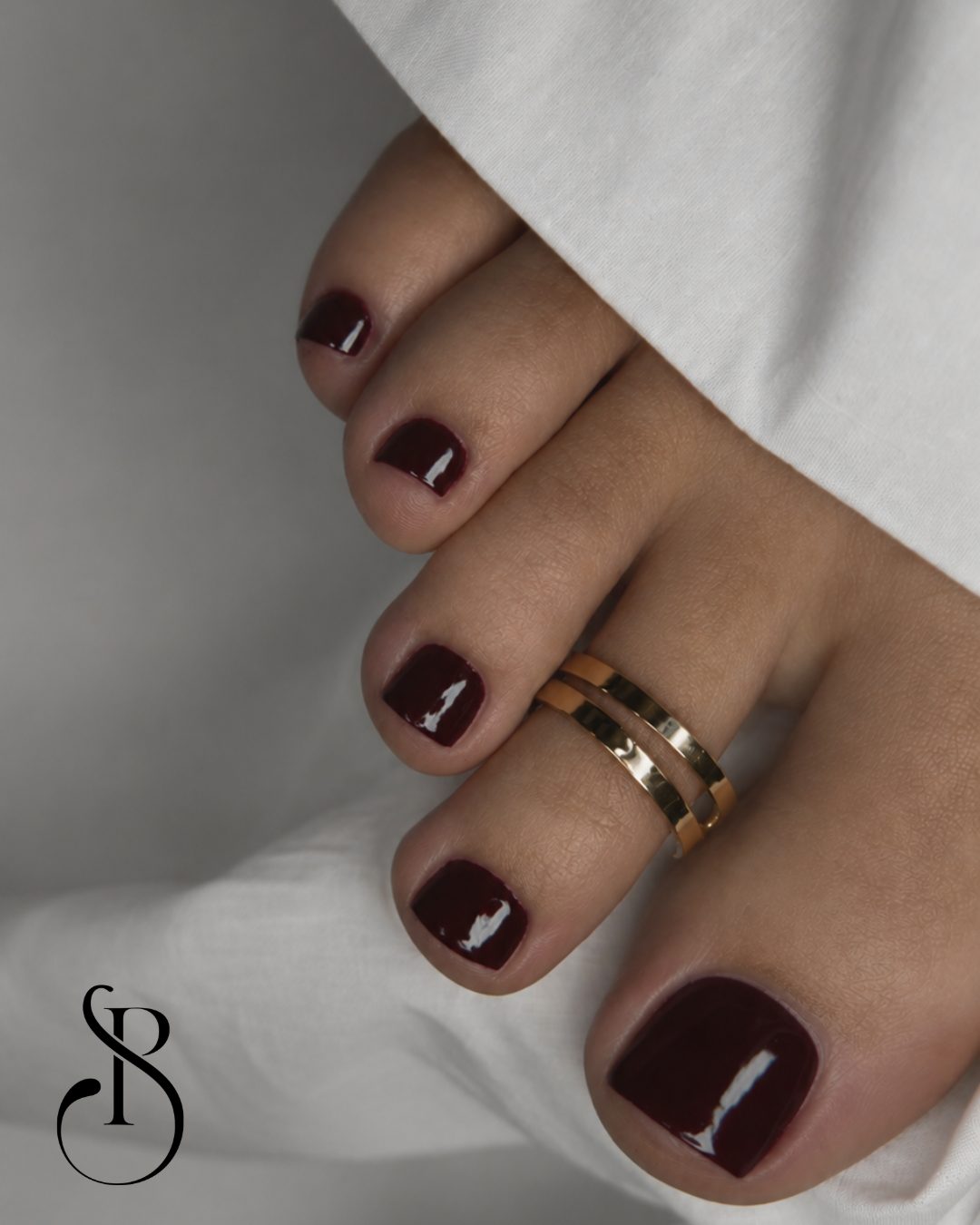 Bordowy pedicure z biżuterią